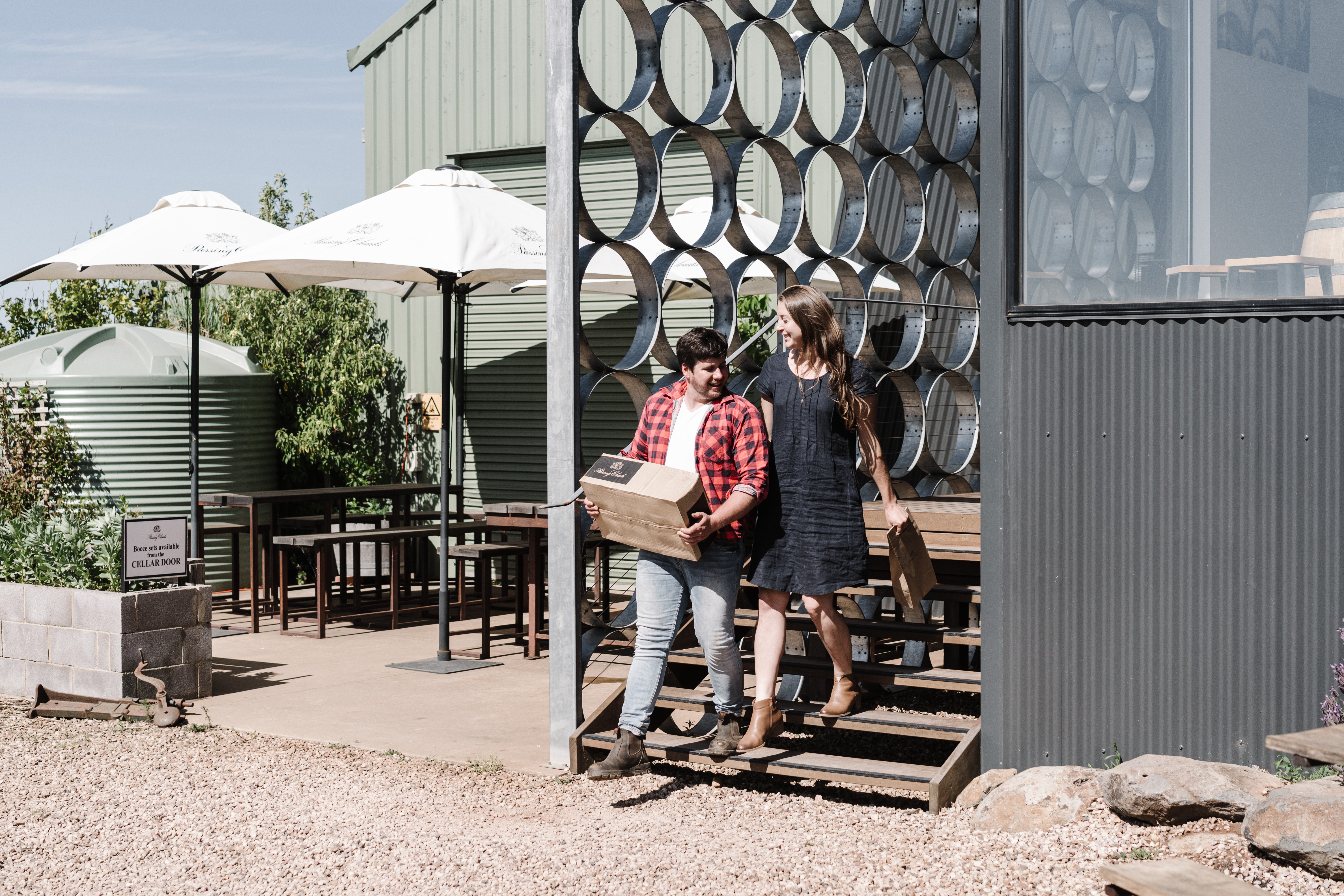 Man carrying out a box of wine with a woman 